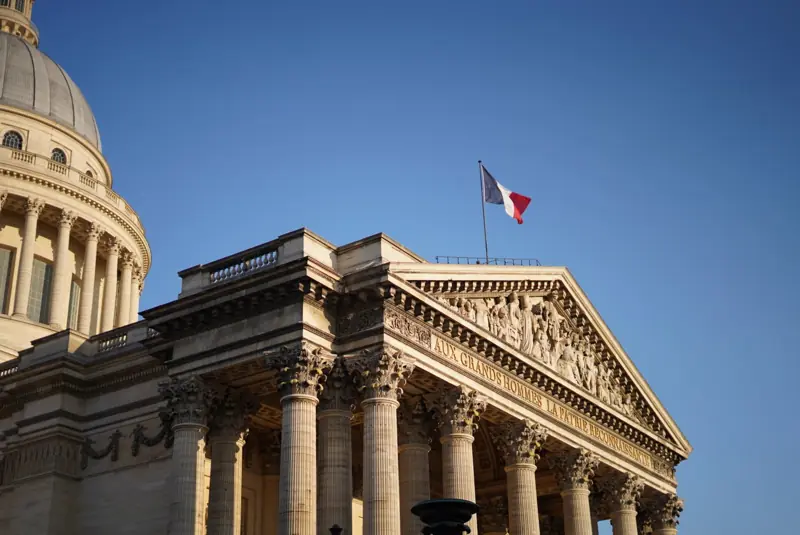 A columned monument in Paris with a French flag on top